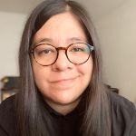 Alejandra Marquez smiles at the camera against a cream backdrop