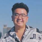 Shawn Luo smiles at the camera against a blue sky